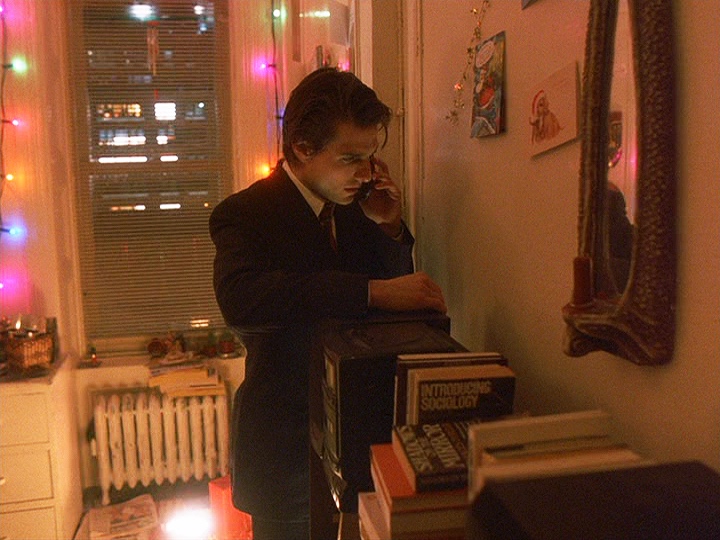 Cruise as Bill Harford in  Eyes Wide Shut  (1999); part of his reflection and half of a mask is visible in a mirror—a book under the mirror is entitled  Shadows on the Mirror